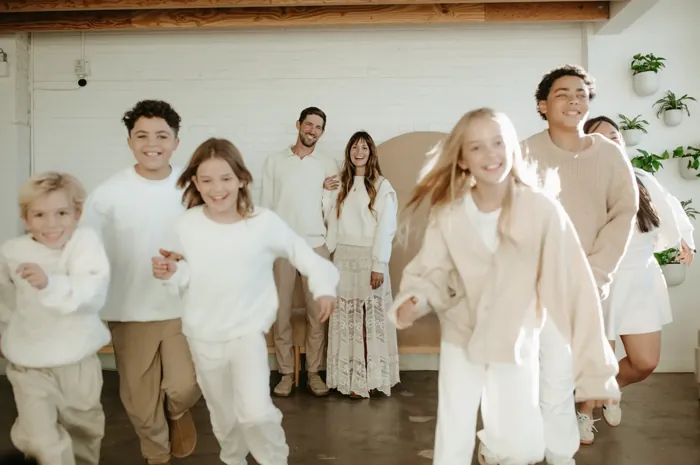 Children running toward the camera with Parker and Jess Manuel smiling behind them